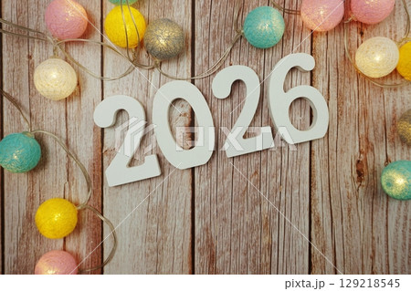 Happy New year 2026 alphabet letter with LED cotton balls decoration on wooden background 129218545