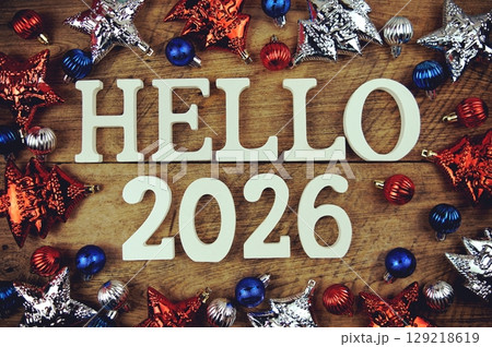 Hello 2026 alphabet letters with christmas decoration on wooden background Hello 2026 alphabet letters with christmas decoration on wooden background 129218619
