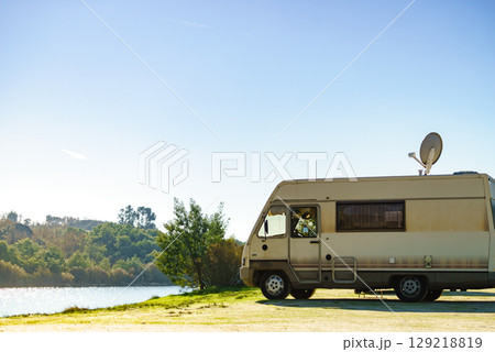 Caravan camping on lake shore with satellite dish on roof 129218819