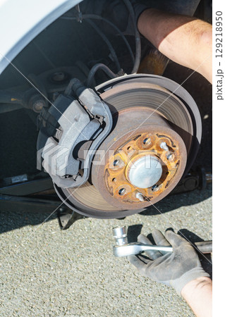 Car in service repairing. Detail of wheel assembly on automobile 129218950