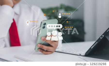 Customer feedback and rating icons displayed on smartphone screen held by hand. Online review, mobile marketing, digital reputation, and user experience concept. Customer feedback and rating icons displayed on smartphone screen held by hand. Online review, mobile marketing, digital reputation, and user experience concept. 129219298