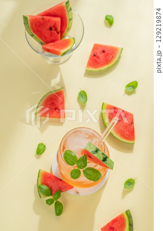 Flat lay of watermelon mojito cocktail with ice and mint in a glass on a yellow background Flat lay of watermelon mojito cocktail with ice and mint in a glass on a yellow background 129219874