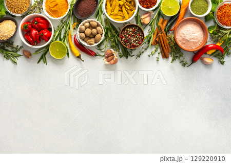 A vibrant assortment of spices and herbs on a gray background, offering a flavorful addition to any recipe, top view and copy space A vibrant assortment of spices and herbs on a gray background, offering a flavorful addition to any recipe, top view and copy space 129220910
