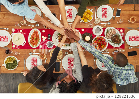 Hands, unity and Christmas with a table setting for dinner or a celebration even with friends from above. Food, together and motivation with a group of people bonding during a meal in the holidays 129221336