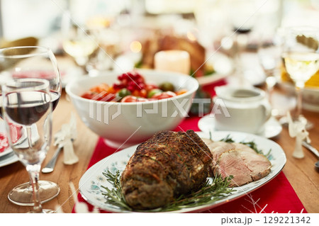 Background, roast beef and thanksgiving food on dining table for dinner party, celebration and christmas, family lunch and meal at home. Closeup of ham, meat and festive feast in fine dining room 129221342
