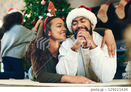Couple hug, christmas and love at party, celebration and happiness on holiday in home living room. Man, woman and embrace to celebrate, romance and happy with smile, care and lounge in family home 129221420