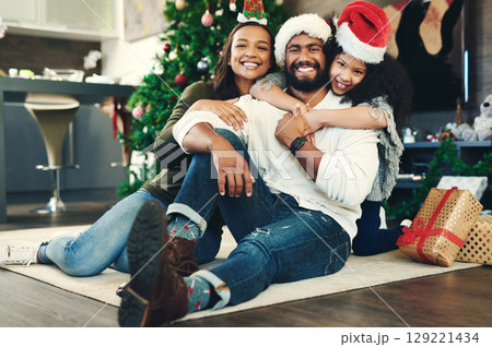 Family portrait, christmas gift and love in holiday celebration, happy smile and relax on floor, decoration and home. Mother, father and girl celebrate festive, happiness and hug at house in brazil 129221434