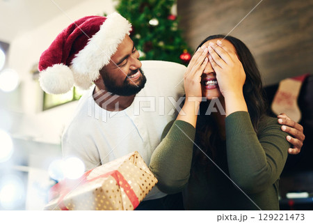 Christmas surprise, gift and couple in home with husband and wife having fun and bonding on holiday. Xmas, love and woman with eyes closed receiving box of presents from man for festive celebration. Christmas surprise, gift and couple in home with husband and wife having fun and bonding on holiday. Xmas, love and woman with eyes closed receiving box of presents from man for festive celebration. 129221473