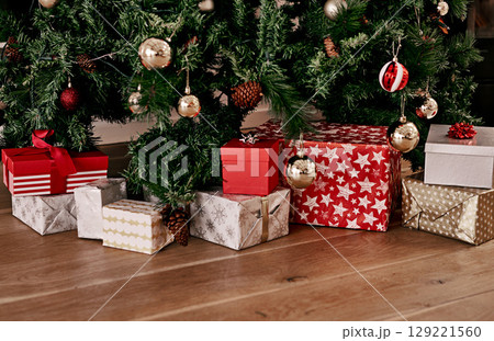 Christmas, floor and box of gift by tree for celebration, festive season and party. Xmas, surprise and gratitude with present on ground of living room with nobody for wow, announcement and holiday 129221560