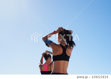 Fitness women, blue sky background and hair tie for cardio exercise, running workout and summer wellness. Healthy female runners, sports athlete and friends prepare for morning training on sky mockup Fitness women, blue sky background and hair tie for cardio exercise, running workout and summer wellness. Healthy female runners, sports athlete and friends prepare for morning training on sky mockup 129221614