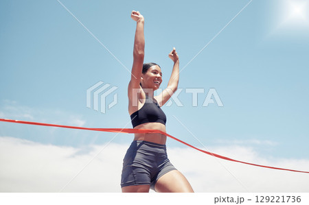 Fitness, winner and sports woman running a race and winning first place in summer in track competition. Runner, goals and happy girl athlete with hands up smile in celebration of a marathon success 129221736