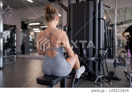Focused on Back exercises sporty woman. Fitness Engaging in Strength Training Activities at the Gym for Optimal Results.  129221824