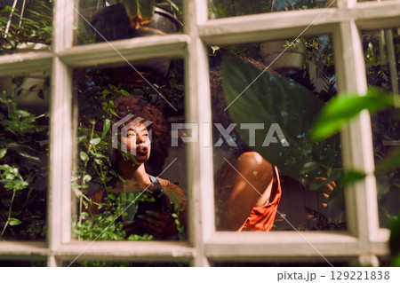 Black women, happy and talking with plants, garden and vegetation in greenhouse. African American females, ladies and gardener planning, conversation for agriculture or discussion for greenery Black women, happy and talking with plants, garden and vegetation in greenhouse. African American females, ladies and gardener planning, conversation for agriculture or discussion for greenery 129221838