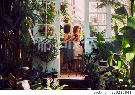 Black women, plants and greenhouse to relax, small business owner and shop florist. African American female, ladies and nature for vegetation, flora or botanic garden for talk, flowers or sustainable Black women, plants and greenhouse to relax, small business owner and shop florist. African American female, ladies and nature for vegetation, flora or botanic garden for talk, flowers or sustainable 129221841
