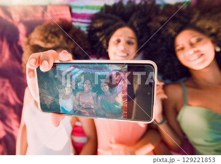 Woman, friends and phone for group selfie, summer and relax for friendship traveling or vacation together. Happy women relaxing lying on beach towels smiling for photo holding smartphone with display Woman, friends and phone for group selfie, summer and relax for friendship traveling or vacation together. Happy women relaxing lying on beach towels smiling for photo holding smartphone with display 129221853
