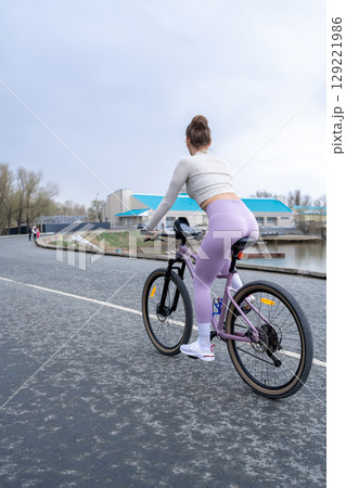 A Woman Riding Her Bicycle by the Water on a Cloudy Day Amidst Natures Beauty 129221986