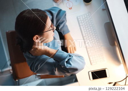 Neck pain, tired and woman in office at night working on project, report or programming issue. Injury, fatigue and muscle tension of coding expert at computer late top view with mockup screen. 129222104