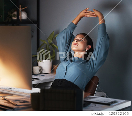 Business woman, stretching or tired at night in office with fatigue, late or planning online proposal. Stretch, stress relief or break from marketing and advertising project in company or workplace 129222106