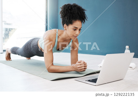 Wellness, fitness and yoga webinar on laptop for healthy and young black woman in body plank position. Focus, balance and online mindfulness in exercise class with girl on floor in home for health. 129222135