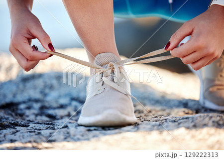 Shoes, running and fitness with a sports woman tying her laces before a cardio or endurance run outdoor. Road, health and exercise with a female runner fastening her shoelaces before a workout Shoes, running and fitness with a sports woman tying her laces before a cardio or endurance run outdoor. Road, health and exercise with a female runner fastening her shoelaces before a workout 129222313