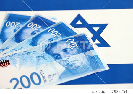 Israel New Shekels banknotes on national flag. The current Israel money bills lies on flag 129222542