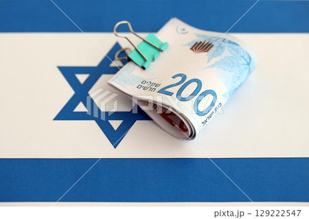 Israel New Shekels banknotes on national flag. The current Israel money bills lies on flag in big amount Israel New Shekels banknotes on national flag. The current Israel money bills lies on flag in big amount 129222547