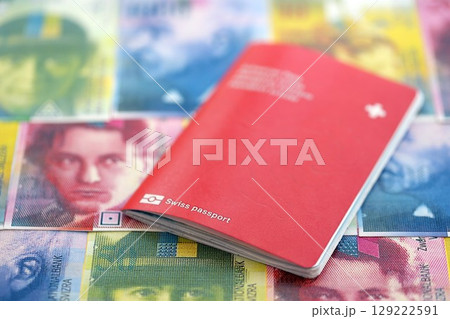 Swiss franc banknotes and passport. The current francs money bills and pass lies on table 129222591