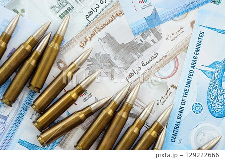 United Arab Emirates dirham currency money bills and rifle bullets. The concept of warfare and gun selling 129222666