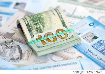 United Arab Emirates dirham currency money bills and bunch of us dollar banknotes. The concept of economics and currency exchange United Arab Emirates dirham currency money bills and bunch of us dollar banknotes. The concept of economics and currency exchange 129222673
