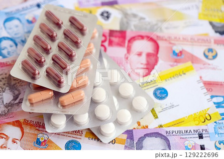 Philippines peso currency money bills and medicine pills. The concept of medicine and pharmacy Philippines peso currency money bills and medicine pills. The concept of medicine and pharmacy 129222696