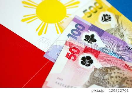Philippines peso currency money bills lies on flag. The concept of business and investment 129222701