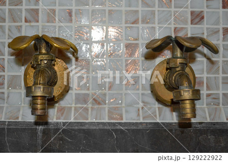 Two vintage petal-shaped taps with cold and hot water in a bathroom Two vintage petal-shaped taps with cold and hot water in a bathroom 129222922