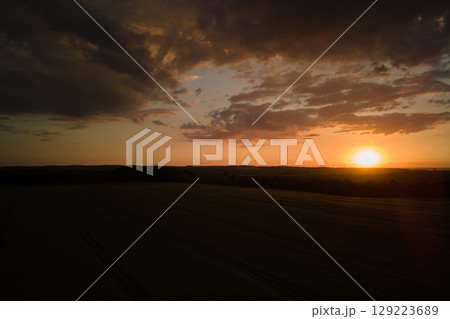 Aerial landscape view of yellow cultivated agricultural field with ripe wheat on vibrant summer evening Aerial landscape view of yellow cultivated agricultural field with ripe wheat on vibrant summer evening 129223689