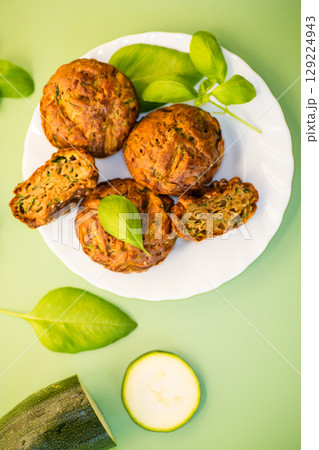 Homemade zucchini muffins on a green isolated background Homemade zucchini muffins on a green isolated background 129224943