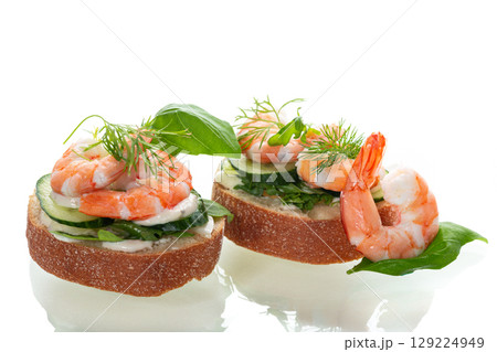 appetizing sandwich with salad and shrimps on a white background appetizing sandwich with salad and shrimps on a white background 129224949