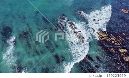 Striated Coastal Cliffs Meeting Turbulent Turquoise Seas 129225969