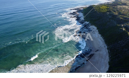 Morning Footsteps Along Serene Sandy Shoreline 129225971