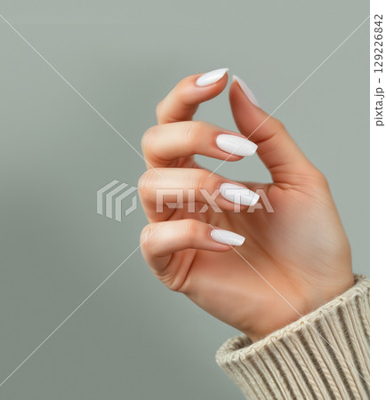 Hand with white squoval nails manicure, ai generated, green background 129226842