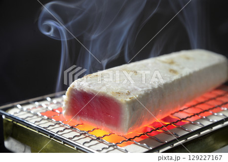 煙の立ち昇る七輪でビンチョウマグロを炙る 129227167