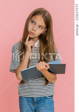 Child girl kid thoughtfully writing notes in notebook diary carefully planning detailed to-do list Child girl kid thoughtfully writing notes in notebook diary carefully planning detailed to-do list 129227277