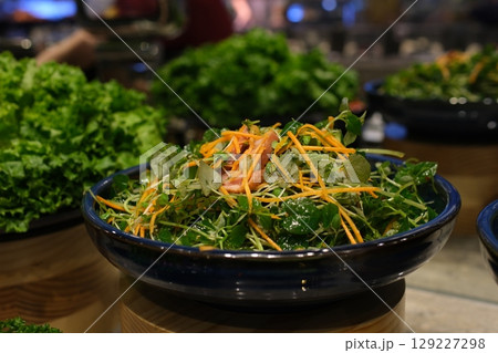 Salad in black bowl at dark background. Healthy green vegetable salad, diet menu. Top view. Salad in black bowl at dark background. Healthy green vegetable salad, diet menu. Top view. 129227298