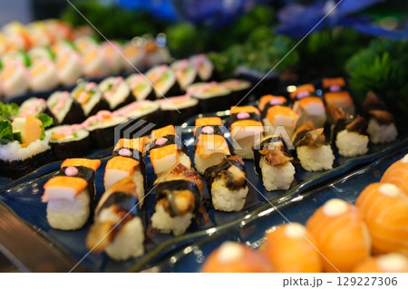 Delicious assortment of sushi rolls is presented on a clean white background, showcasing the variety and artistry of japanese cuisine 129227306
