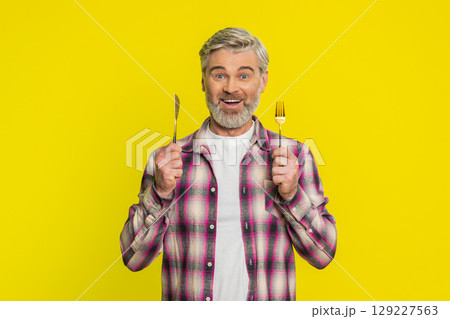 Hungry man waiting for serving dinner meal dishes with restlessness holding cutlery fork knife Hungry man waiting for serving dinner meal dishes with restlessness holding cutlery fork knife 129227563