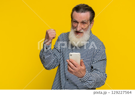 Happy excited winner old man use smartphone celebrating success, winning play game good lottery news 129227564