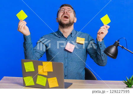 Nervous man with pasted sticker notes use laptop having concentration problem big routine work Nervous man with pasted sticker notes use laptop having concentration problem big routine work 129227595