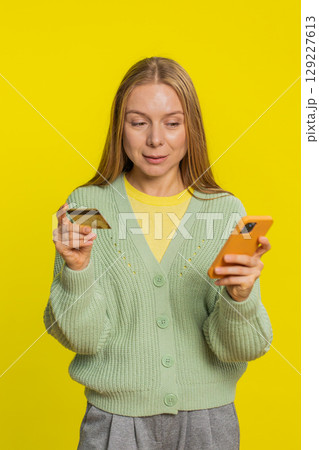 Woman use credit bank card smartphone while transferring spending money, purchases online shopping 129227613