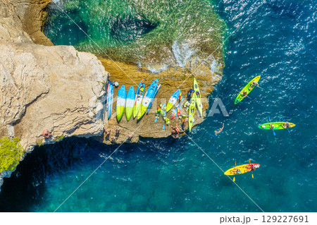 Kayaking. Sup. Aerial view of floating board and people on blue sea at sunny day. Kayaking. Sup. Aerial view of floating board and people on blue sea at sunny day. 129227691
