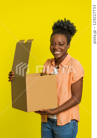 Black woman unboxing delivery package, excited expression, online shopping gift, quick service Black woman unboxing delivery package, excited expression, online shopping gift, quick service 129227733