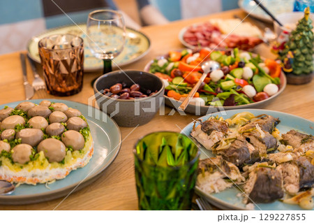 Cose-up of a festive Christmas dinner spread on a wooden table. Homemade dishes 129227855