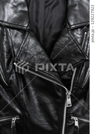 Close-up of shiny black faux leather biker jacket with silver zippers and snap button collar 129227922